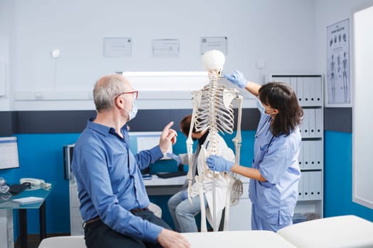 Nurse explains human skeleton to patient