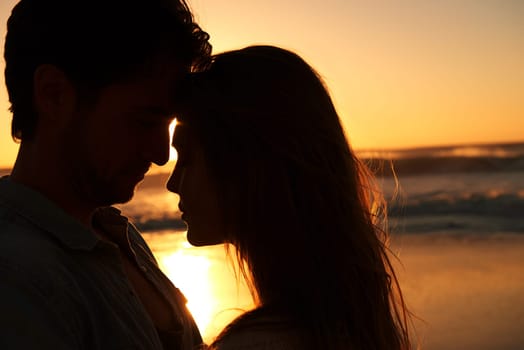 Couple, beach and sunset or silhouette embrace on vacation for coast holiday, connection or bonding. Man, woman and love hug at sea ocean for summer travel or evening journey, explore or marriage.