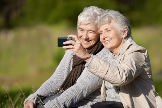 Senior friends, outdoor and selfie for photography, picture and happy for memories in nature and elderly. Women, bonding and chatting with smile, funny and laughing together in retirement