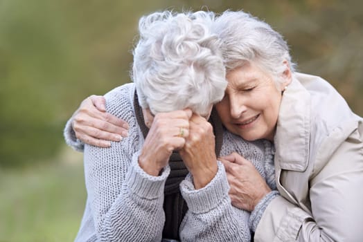 Senior woman, empathy and crying in nature, depression and grief in outdoor environment. Elderly people, garden and comforting or consoling in park, sadness and friend hugging for care in retirement