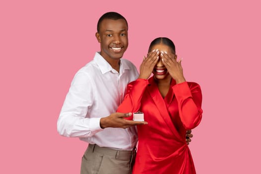 Black man surprises woman with ring, woman overjoyed closing eyes