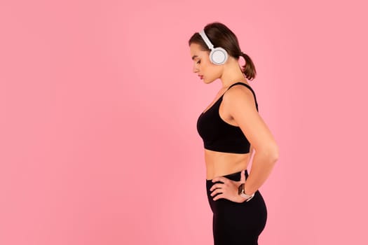 Side profile of determined young female athlete wearing wireless headphones