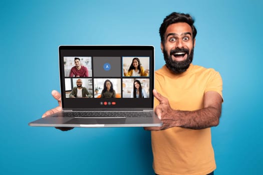 Excited indian man showing laptop with video call screen