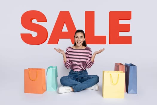 woman sitting with shopping bags on background with word SALE