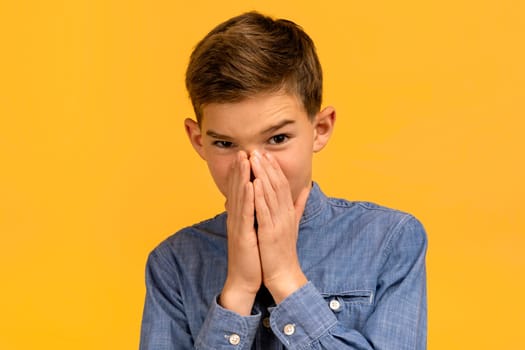 Teen boy with look of disgust pinching nose to avoid bad smell