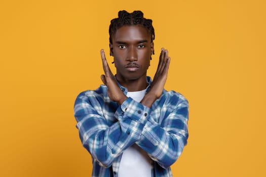Portrait Of Young Black Guy Showing Stop Gesture With Crossed Hands