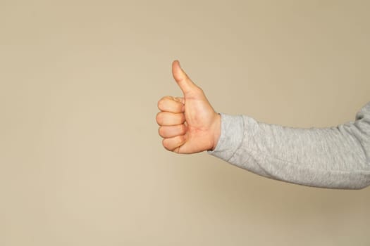 Thumb up isolated on beige background, with clipping path, concept Admiration, Excellent