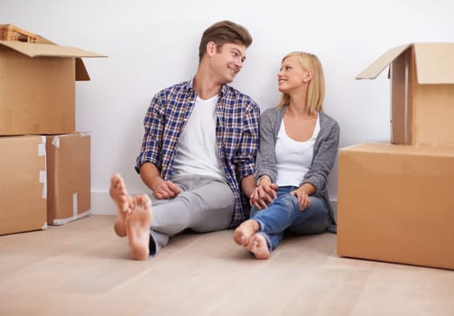 Couple, moving and new home with boxes for packing, real estate and happy holding hands for support. Property, achievement or investment with people and cardboard for relocation, mortgage or rent