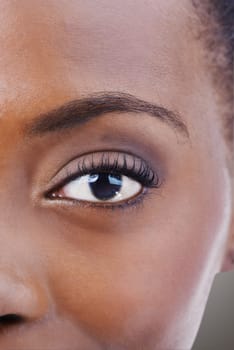 Eyeshadow, makeup and black woman closeup with beauty and skincare on half of face. Eye, portrait and African model with healthy glow and shine on skin from dermatology, cosmetics or foundation