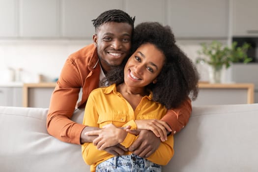 Cheerful African American Husband Hugging Wife In Modern Living Room