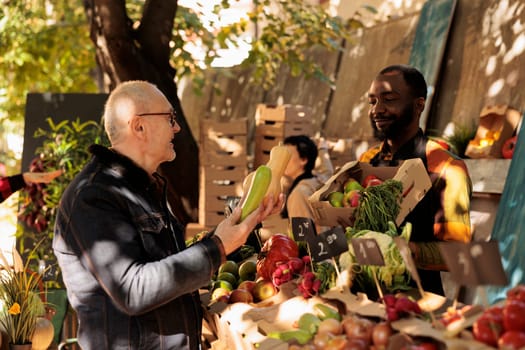 Senior man buying fresh organic vegetables at farmers market