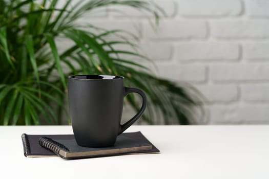 Coffee mug on table against brick wall