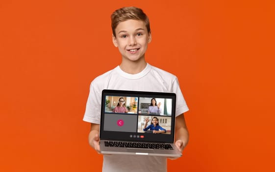 Cute boy teenager showing laptop with online lesson screen