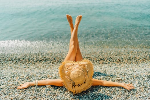 Beach Relaxation woman lies on a pebble beach, legs raised, and arms spread out. The concept of travel, vacation at sea