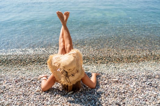 Beach Relaxation woman lies on a pebble beach, legs raised, and arms spread out. The concept of travel, vacation at sea