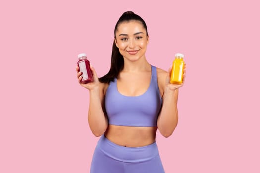 Confident woman presenting juice and smoothie bottles