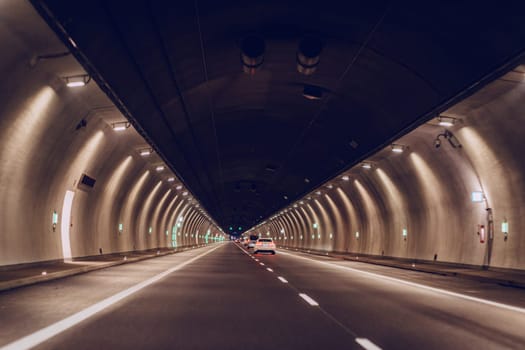 Underground asphalt road tunnel with yellow lights