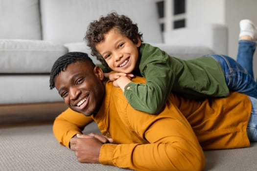 Black father and son share playful moment on the floor