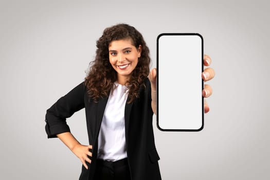 Businesswoman presenting smartphone with blank screen