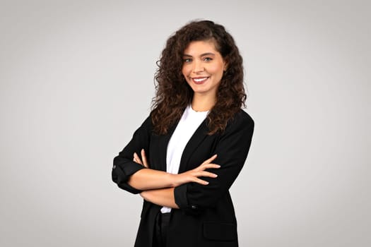 Confident businesswoman with crossed arms smiling