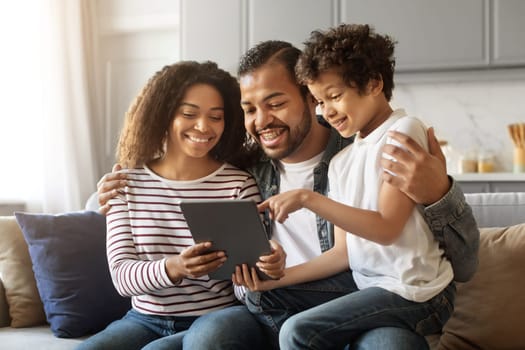 Cheerful African American Parents And Little Son Relaxing With Digital Tablet