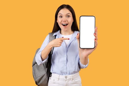 Excited female student showing blank phone screen