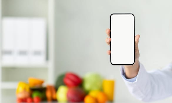 Cropped of woman nutritionist showing phone with blank screen
