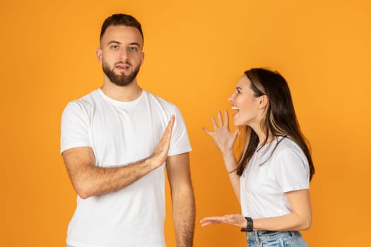A man in a white shirt shows a stop gesture with his hand while a woman