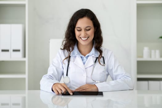 Professional confident millennial woman doctor writing prescription at tablet