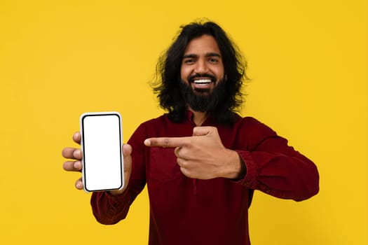 Positive hindu guy showing cell phone with white empty screen
