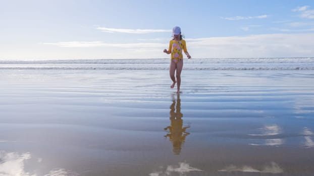 Little Girl Joyfully Running on Winter Beach