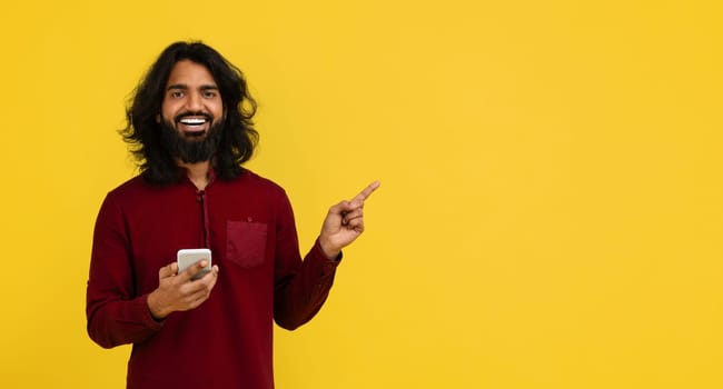 Positive young indian man using smartphone, copy space