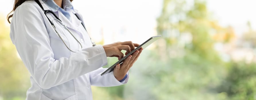 Cropped of woman doctor in white coat work on tablet
