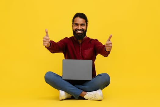 Positive cool indian guy freelancer working on laptop