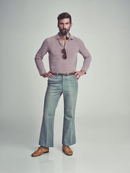 Retro, fashion and portrait of man with 70s vintage aesthetic in gray background of studio. Smoking, pipe and person with confidence and pride in funky clothes and unique style from past or history
