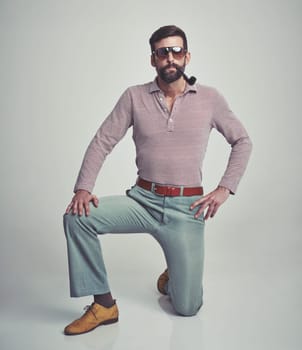 Vintage, fashion and portrait of man with 70s retro aesthetic in gray background of studio. Smoking, pipe and person with confidence and pride in funky sunglasses, clothes and unique style from past