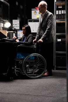 Paralyzed executive in wheelchair at desk
