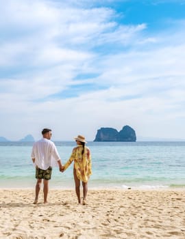 happy young couple Asian woman and European men on the beach of Koh Ngai island in Thailand