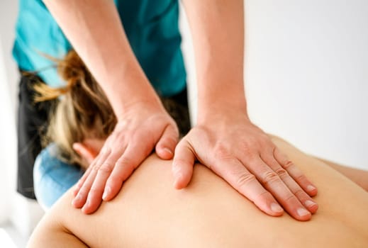Massage therapist doing back relax massage in spa