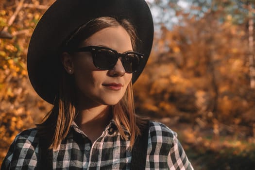 Hipster woman portrait, autumn park, beautiful golden nature. Lifestyle, hat.