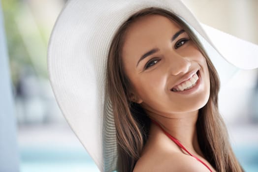 Relax, portrait and happy woman at pool with hat, sunshine and travel for summer holiday at hotel. Smile, water and face of girl on luxury vacation with adventure, weekend and swimming in sun in USA