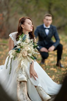 bride wearing white boots holding beautiful bouquet.