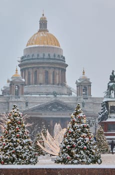 Russia, St Petersburg, St. Isaac's Cathedral and the monument to Emperor Nicholas II through lighting decorations during snowstorm, streets decorated for Christmas