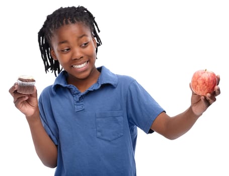 Kid, apple and cupcake in studio with smile for thinking, contemplating and decision on snack. Black child, happy and unsure with choosing for lifestyle, fruit or sweet dessert on white background