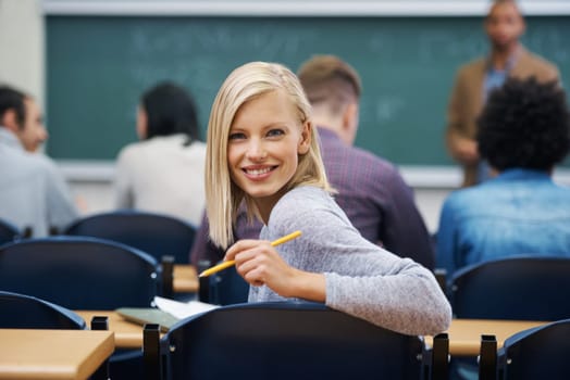 University student, portrait and smile at classroom desk in London for english lecture, education or scholarship. Female person, face and pen at academy with professor for teaching, lesson or exam