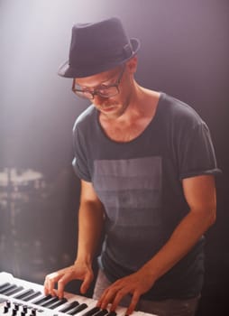Jazz musician, playing and piano on stage at night for solo performance and album launch in Canada. Hipster with electronic keyboard at rock, music and festival for sound, audio and live gig
