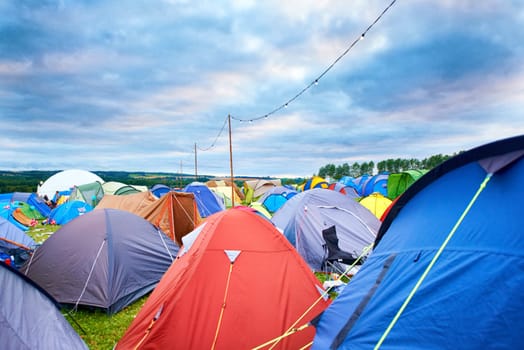 Camping, tents and outdoor music festival in park on holiday or vacation in summer. Camp, site and shelter setup at party, event or travel in countryside for concert, adventure and crowded carnival