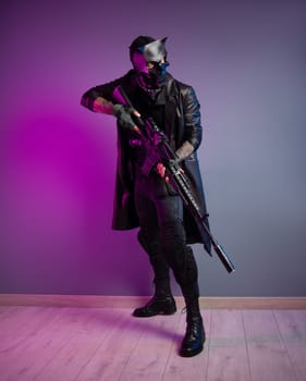 A tough guy killer in a demon mask and black raincoat with a sniper airsoft rifle in his hands
