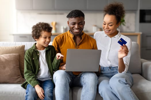 Black family shopping online together with laptop and credit card