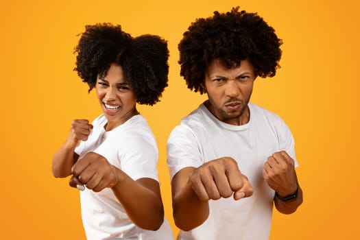 Young african american couple showing fists on background